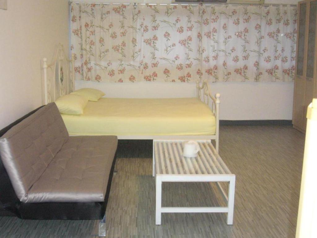 a room with a bed and a couch and a chair at Chan Kim Don Mueang Guest House, located in Pak Kret in Thung Si Kan