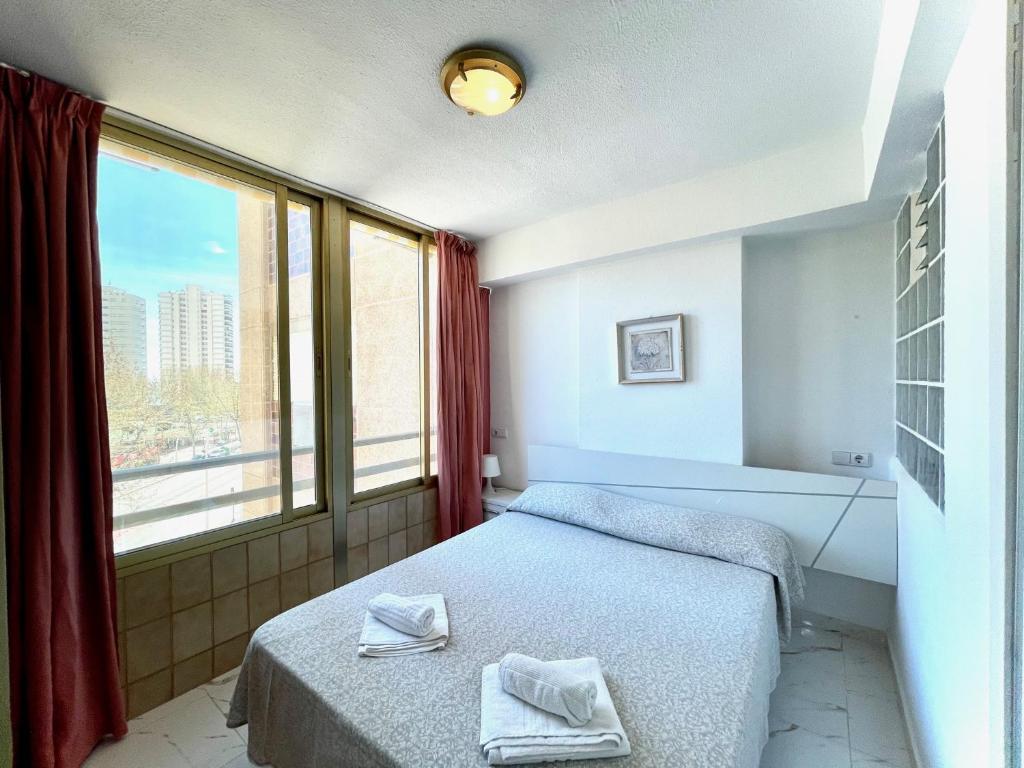 a bedroom with a bed and a large window at Mariscal 1 - Aloturin Benidorm in Benidorm