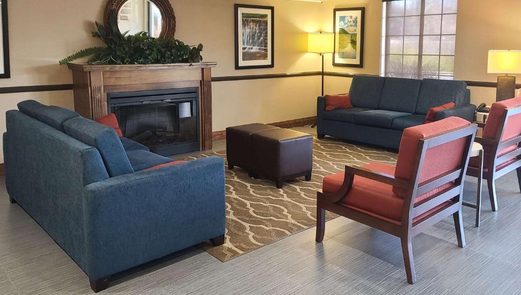 a living room with two couches and a fireplace at Comfort Inn New River in Oak Hill