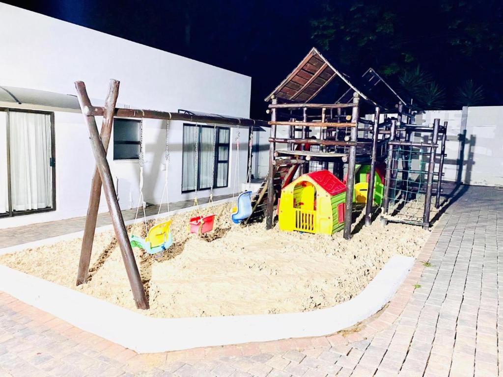 a playground in the sand in front of a building at C&C HOTEL VIBES Randpark Ridge JHB 14 Units Available in Boskruin