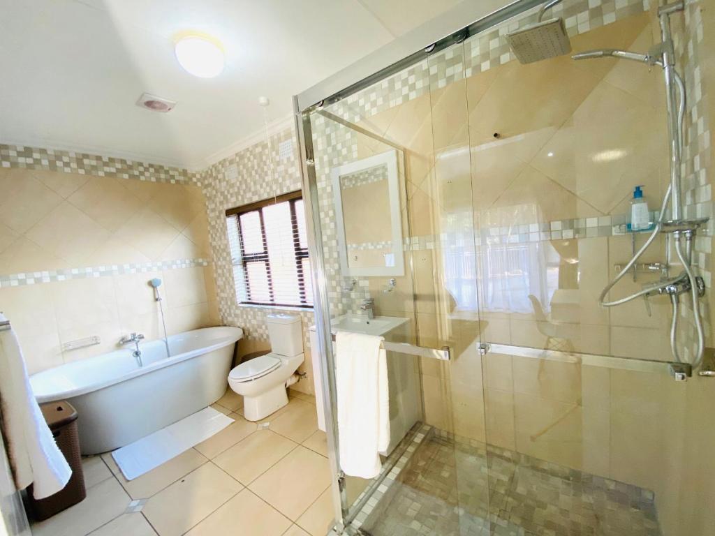 a bathroom with a tub and a toilet and a shower at C&C HOTEL VIBES Randpark Ridge JHB 14 Units Available in Boskruin