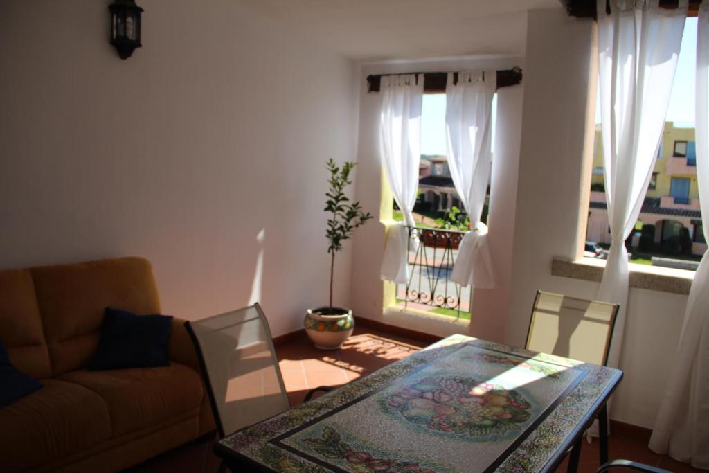 a living room with a table and a couch at Appartamento Le Vele in Porto San Paolo