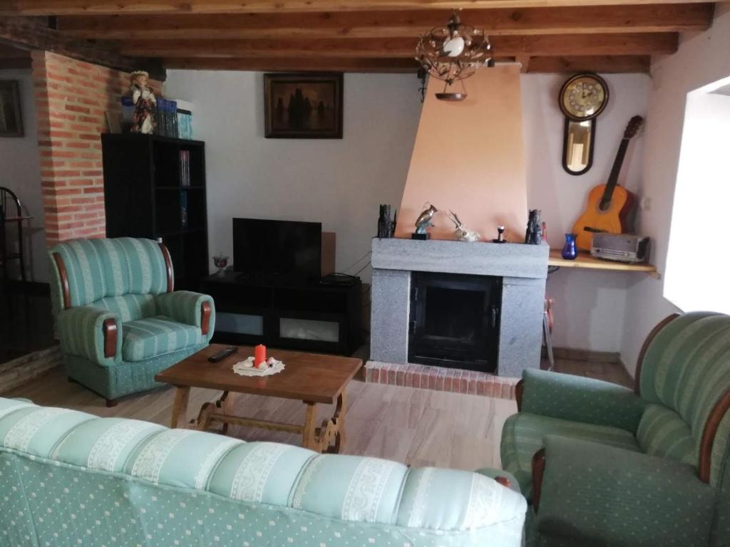 - un salon avec deux canapés et une cheminée dans l'établissement Vivienda Vacacional Los Picuos - Casas de los Picos, à Robriguero