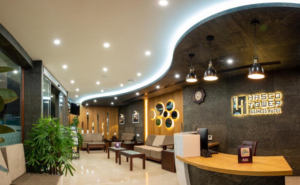 a lobby of a hotel with tables and chairs at Hasco Tower in Palakkad