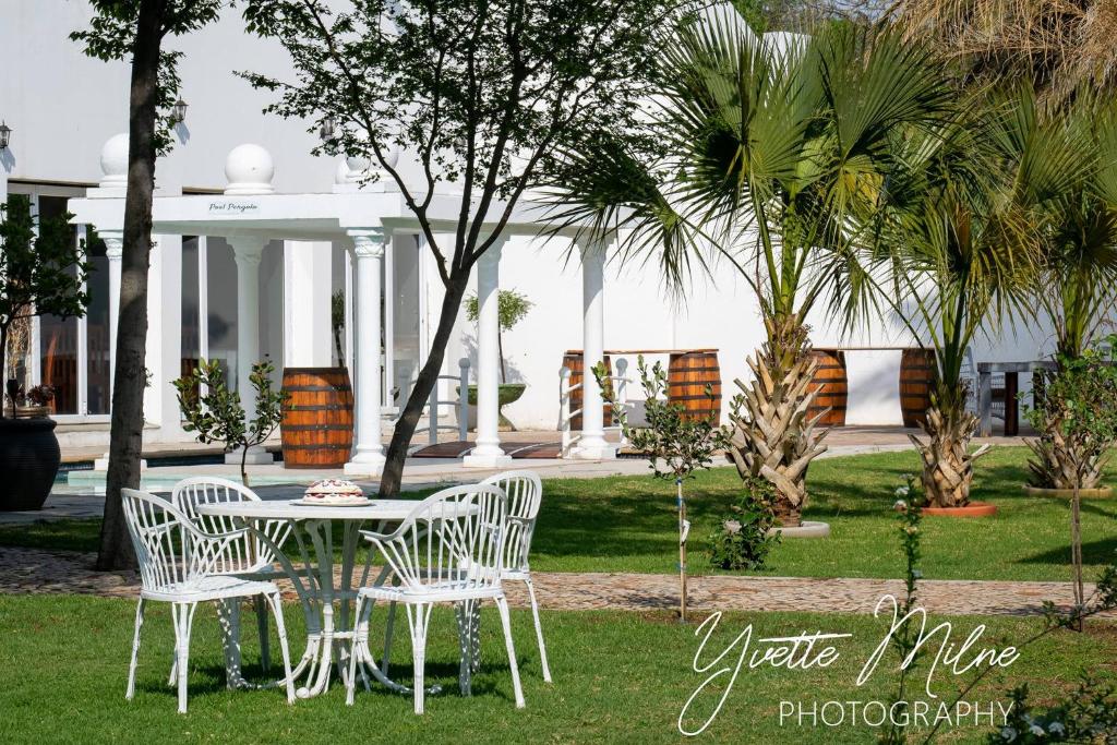 biały stół i krzesła przed domem w obiekcie Fountain Villa w mieście Klerksdorp