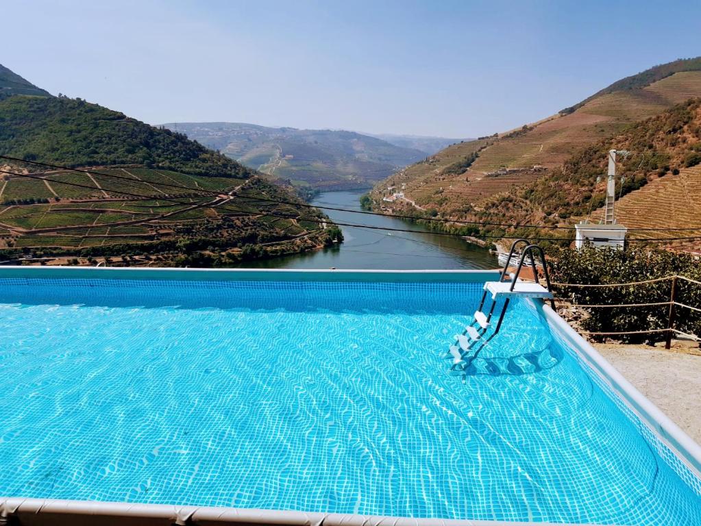 a swimming pool with a view of a river at Quinta da Galeira in Pinhão