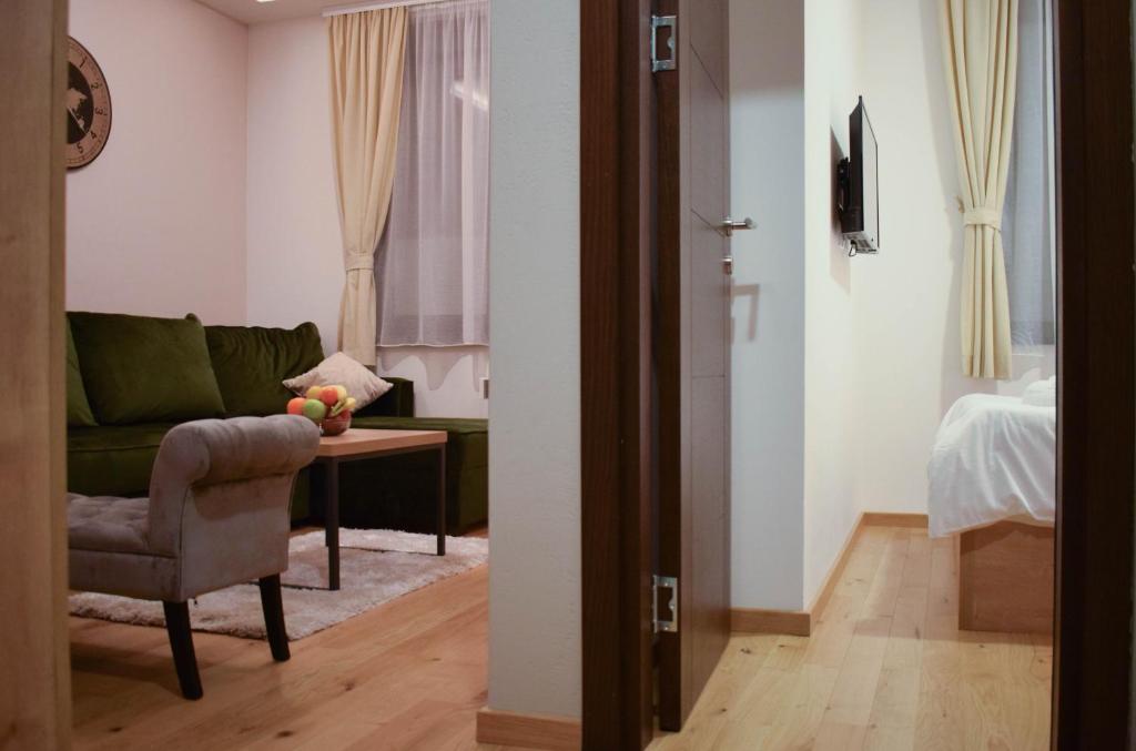 een woonkamer met een groene bank en een tafel bij Apartman Spas Titova Vila Zlatibor in Palisat