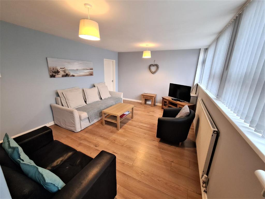 uma sala de estar com um sofá e uma mesa em 3 Bedroom Apartment Coventry - Hosted by Coventry Accommodation em Coventry