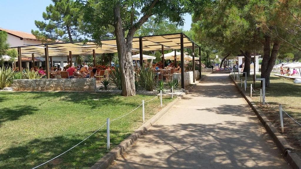 restauracja z ludźmi siedzącymi przy stolikach w parku w obiekcie Apartment in Medulin with Terrace, Air conditioning, Wi-Fi, Washing machine (3479-1) w Medulinie