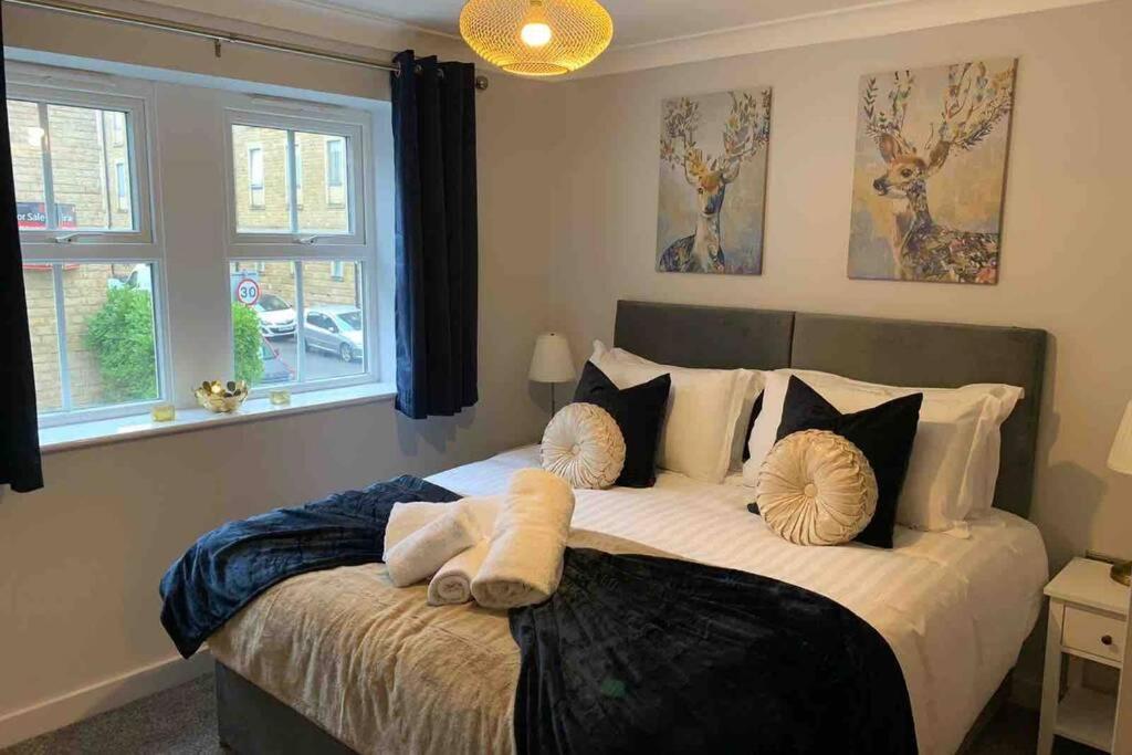 een slaapkamer met een groot bed met kussens erop bij The Mowbray in Harrogate