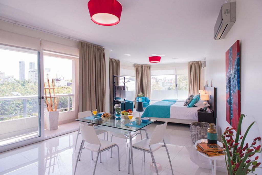 Schlafzimmer mit einem Bett, einem Tisch und Stühlen in der Unterkunft Soho Luxury Suites in Buenos Aires