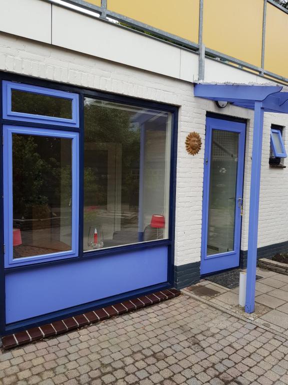 a building with blue windows on the side of it at Vakantiehuisje Te Gast op Texel in Den Burg