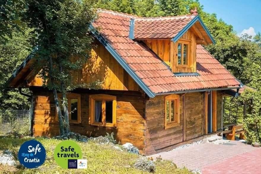 eine kleine Blockhütte mit rotem Dach in der Unterkunft Holiday Home David in Slunj