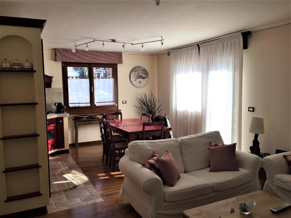 uma sala de estar com um sofá branco e uma mesa em House le Betulle em Sauze dʼOulx