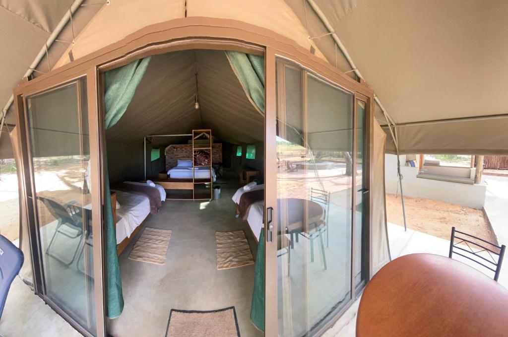 all'interno di una tenda con tavolo e letto di Limpopo Bushveld Retreat a Vaalwater