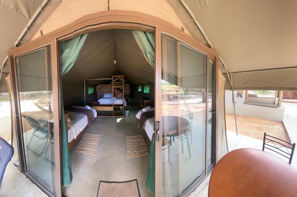 En el interior de una tienda de campaña con una mesa y una cama en Limpopo Bushveld Retreat, en Vaalwater