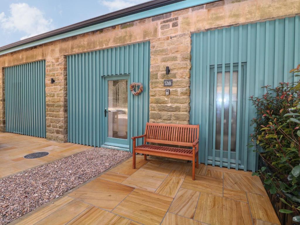 einer Holzbank auf der Außenseite eines Gebäudes in der Unterkunft Oak Cottage in Sheffield