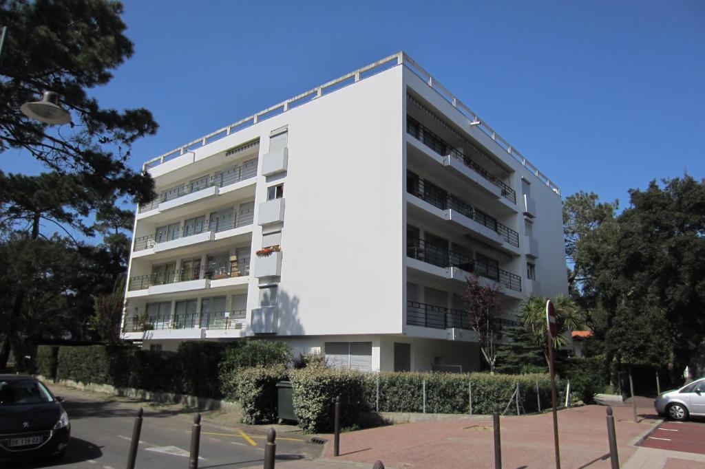 un edificio blanco con coches estacionados frente a él en Appartement Pour 4 Personnes- Residence Sporting House, en Hossegor