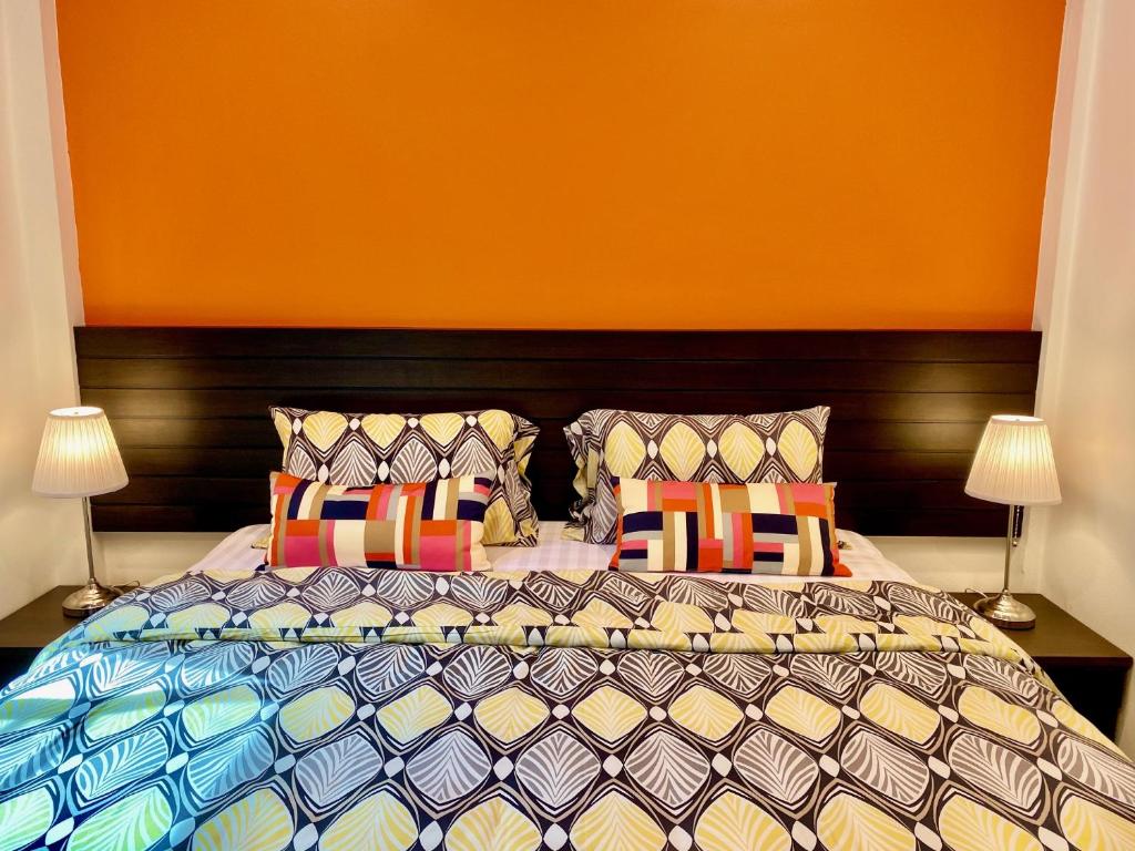 a bedroom with a large bed with colorful pillows at YinDee Lanta Villas in Ko Lanta