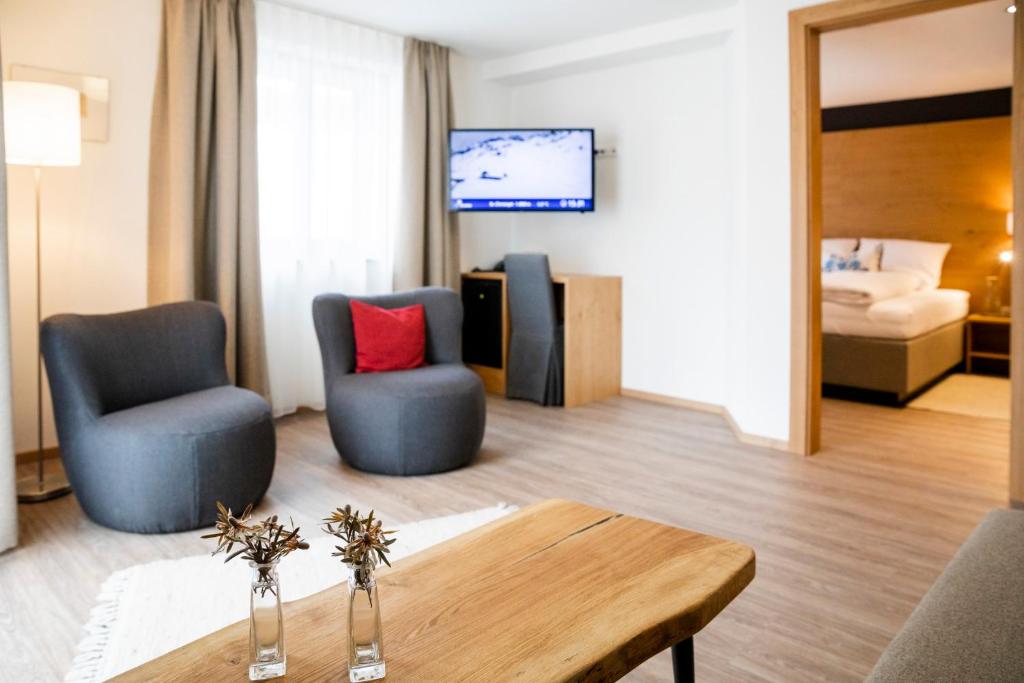 a living room with two chairs and a table at Hotel Montfort in Sankt Anton am Arlberg