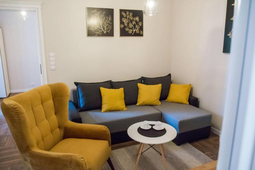 a living room with a blue couch and yellow pillows at Gold Garden in Toruń