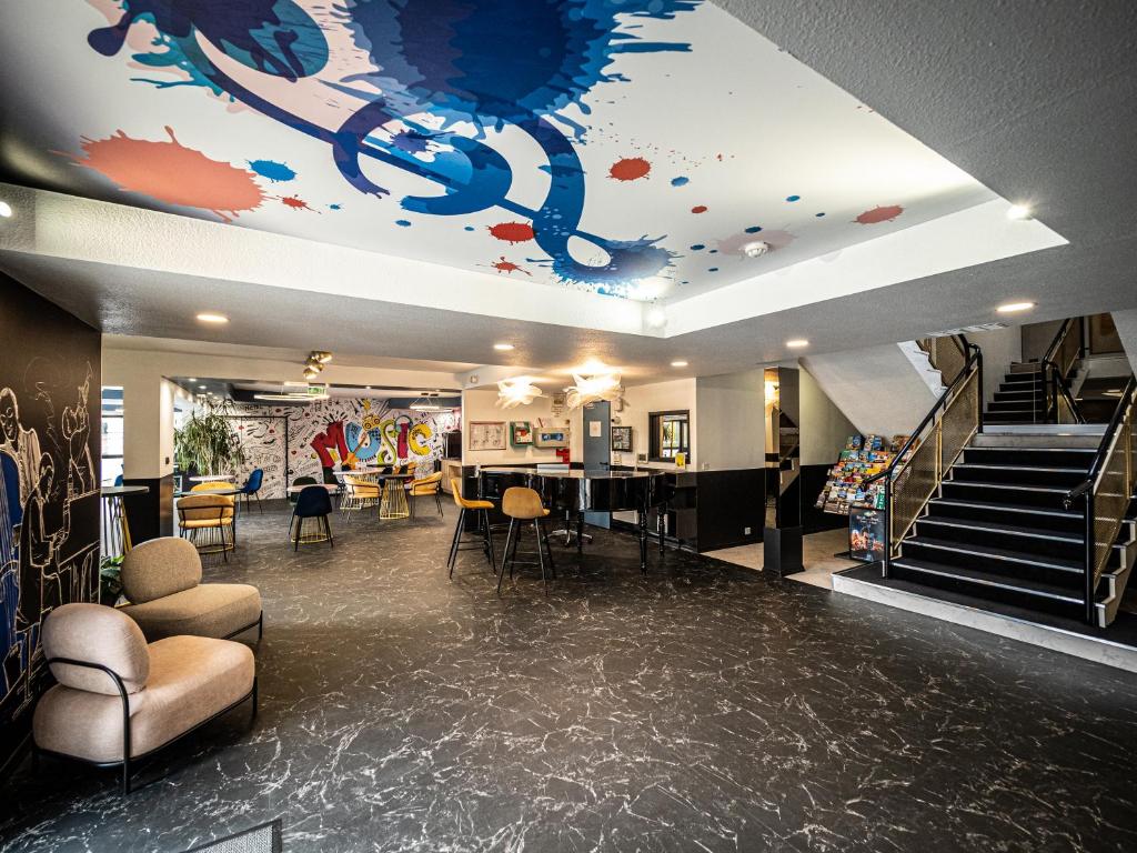 a lobby with a painting on the ceiling and stairs at Welcomotel Beauvais Aéroport in Beauvais