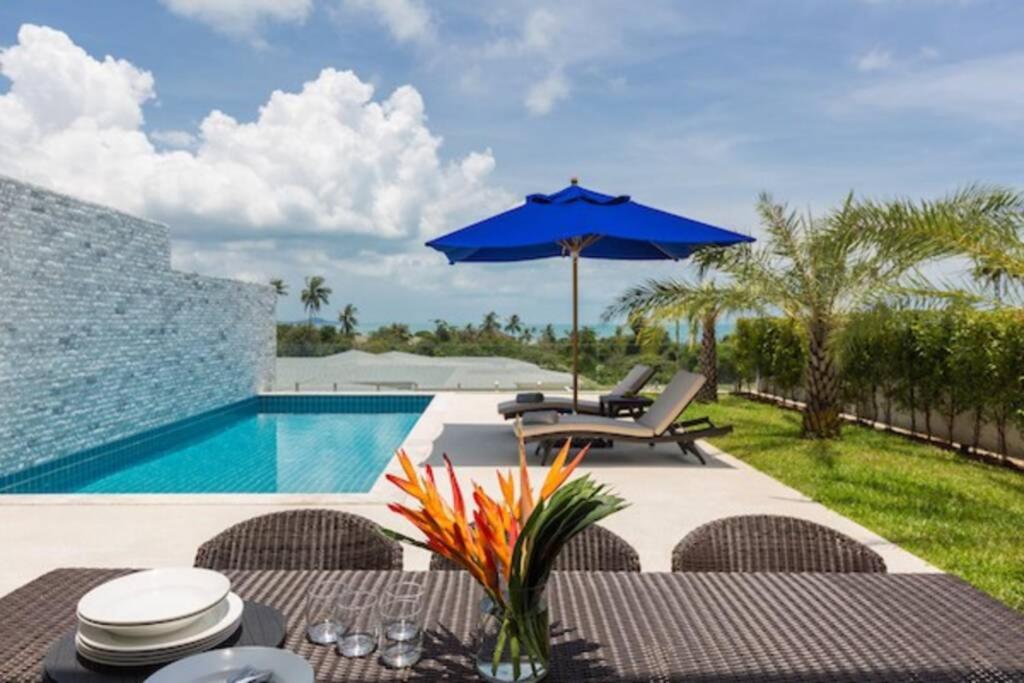 een patio met een tafel met een parasol en een zwembad bij **75% DISCOUNT** 3 Bed/4 Bath SEA VIEWS BIG GARDEN in Koh Samui 