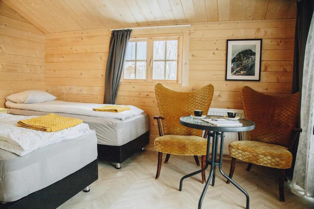 um quarto com duas camas e uma mesa e cadeiras em Rauðuskriður farm em Hólmabæir