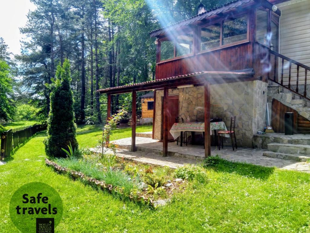 a house with a deck and a table in a yard at Villa Vanessa Koprivki Area in Tsar Kaloyan