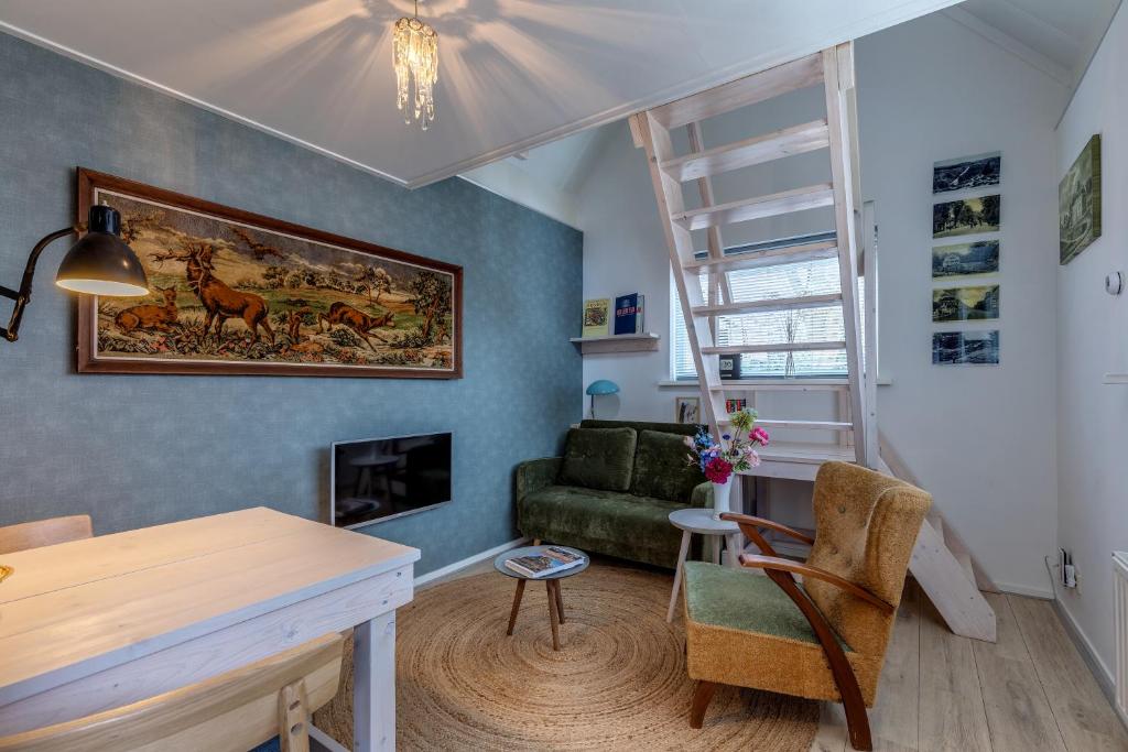 a living room with a table and a couch at B&B Larenstein logeren in een tiny house in Velp