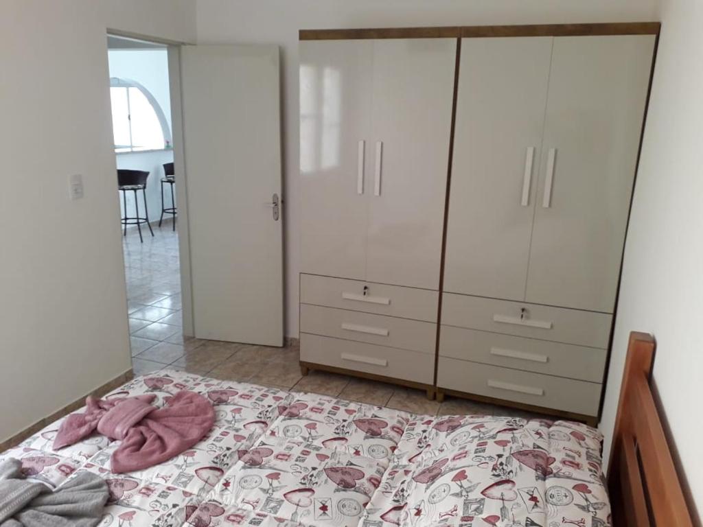 Schlafzimmer mit einem Bett mit einer Kommode und Schränken in der Unterkunft Casa Temporada Castelinho Campinas in Campinas