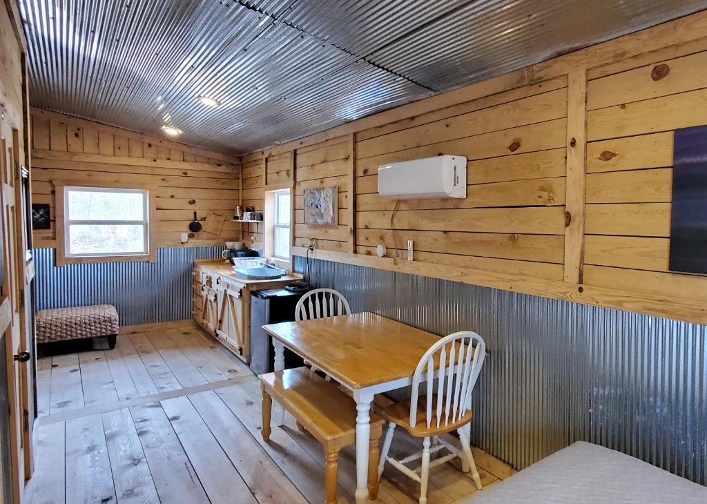una cucina con pareti in legno, tavolo e sedie di Stay In Current a Jadwin