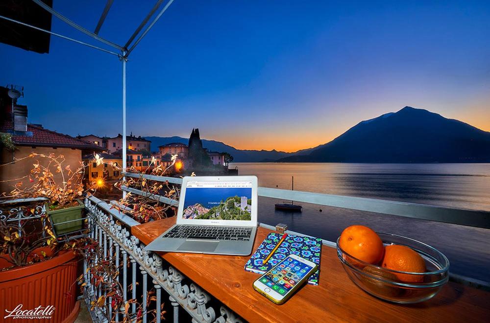 un computer portatile seduto su un tavolo sul balcone di Casa Veranda a Varenna