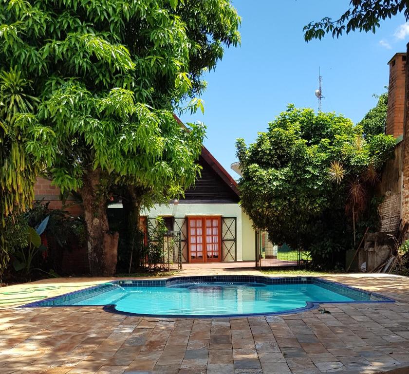 una piscina di fronte a una casa di Casa Folks Bed and Breakfast a Puerto Iguazú