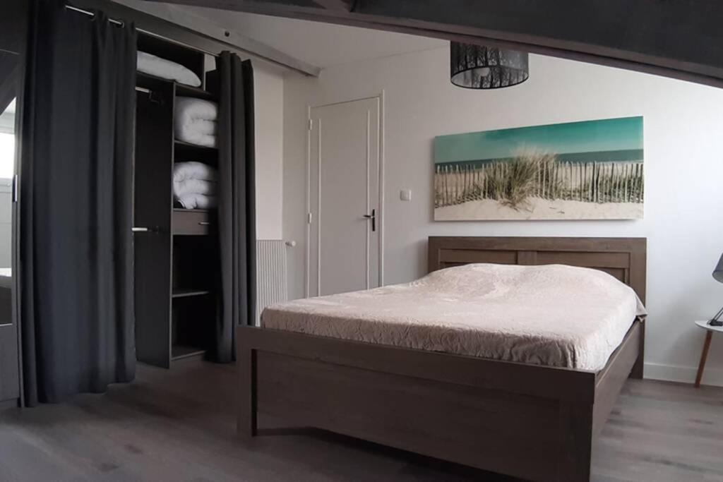um quarto com uma cama e um quadro na parede em Villa Argentine T2 classé 2* thème Beach em Dax