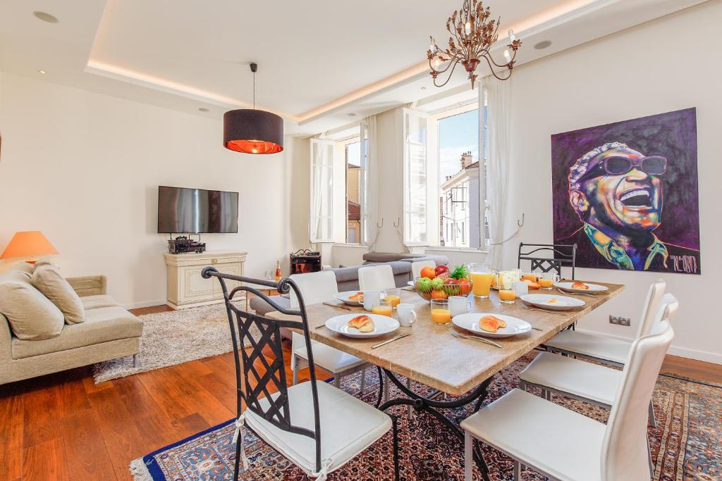 una sala da pranzo con tavolo, sedie e un quadro di Villa Maiffret 1 YourHostHelper a Cannes