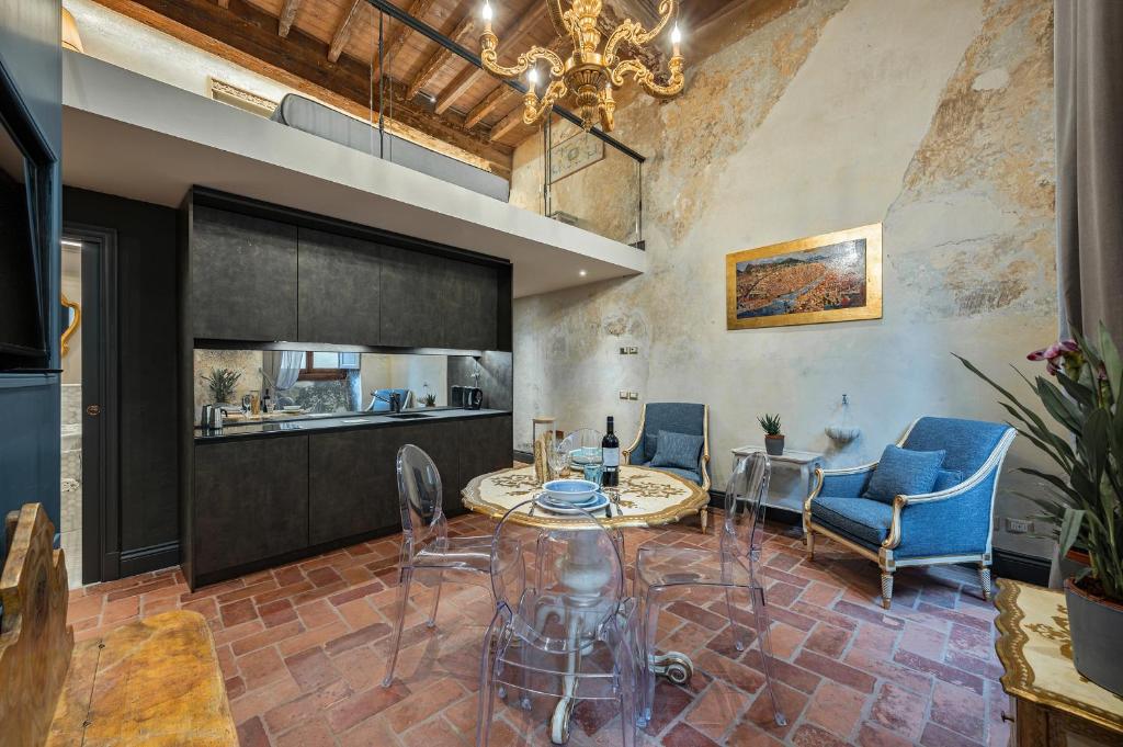 a living room with a table and chairs and a kitchen at Soggiorni D'Arte Apartments by Mamo Florence in Florence