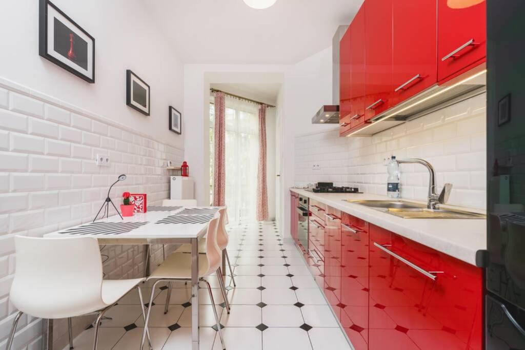 a kitchen with red and white cabinets and a counter at Modern Urban Escape - Old Town Apartment in Krakow