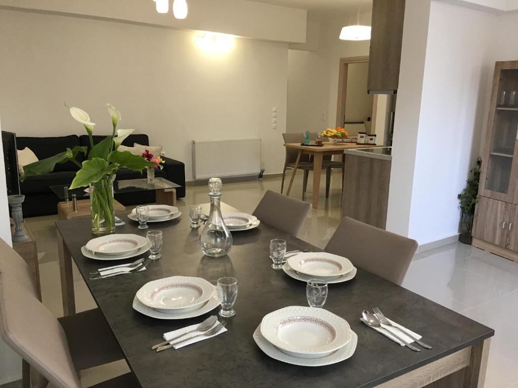 a dining room table with plates and silverware on it at Stylish home - comfortable holidays near the beach. in Panormos Rethymno