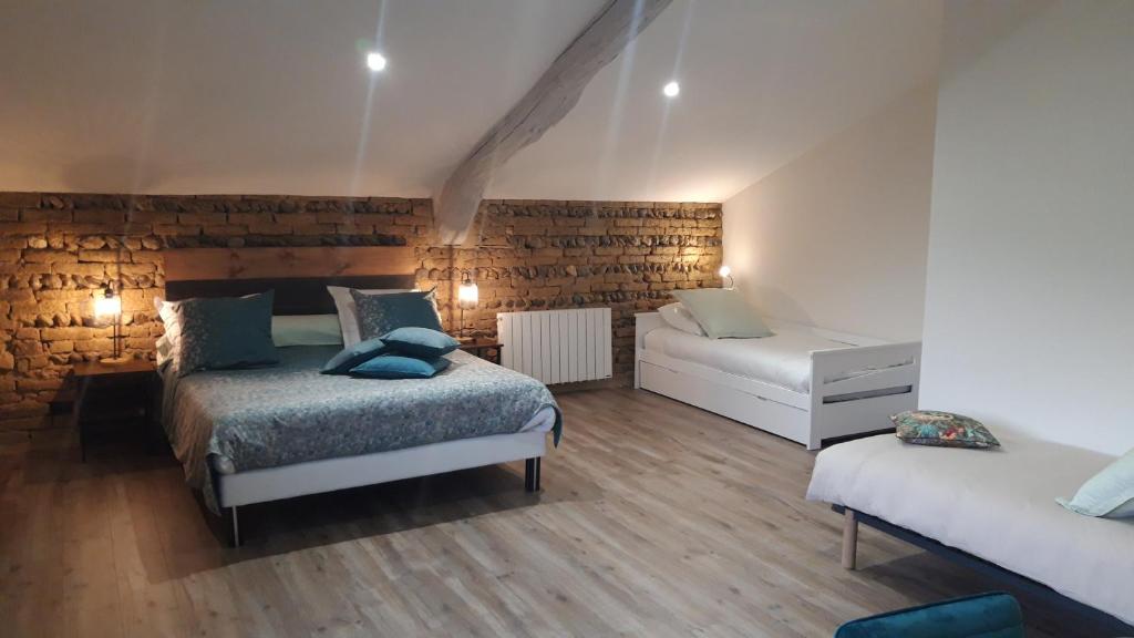 a bedroom with two beds and a couch in it at Les Chambres de Lili in Saint-Loup