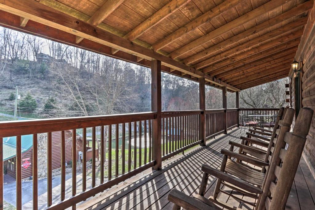 a porch with wooden benches on a deck at 3 Mi to Dollywood Hot Tub Hideaway in Smoky Mtns in Pigeon Forge
