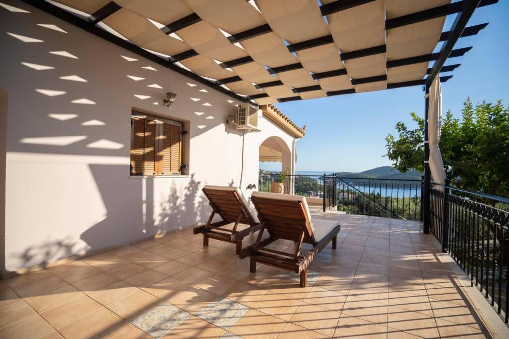 a patio with two chairs and a view of the ocean at Great View villa in Sivota