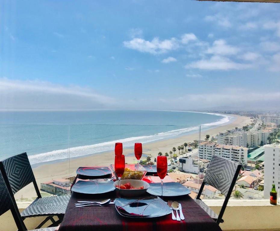 a table with a view of the beach and the ocean at La Choza VIP Roja in Coquimbo