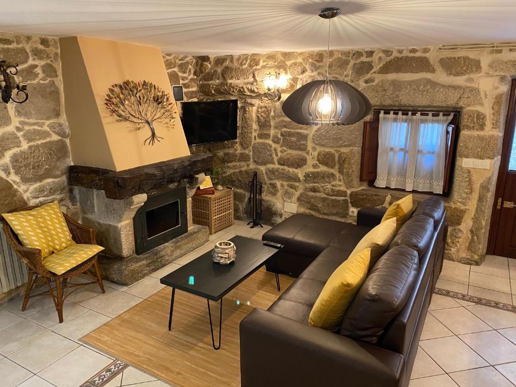 a living room with a couch and a stone fireplace at Casa Rualeira in Combarro
