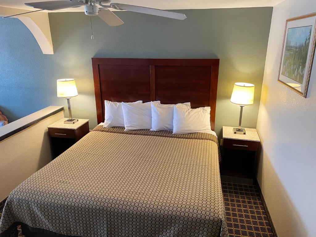 a hotel room with a bed with two lamps at Great Western Inn & Suites in Carlsbad