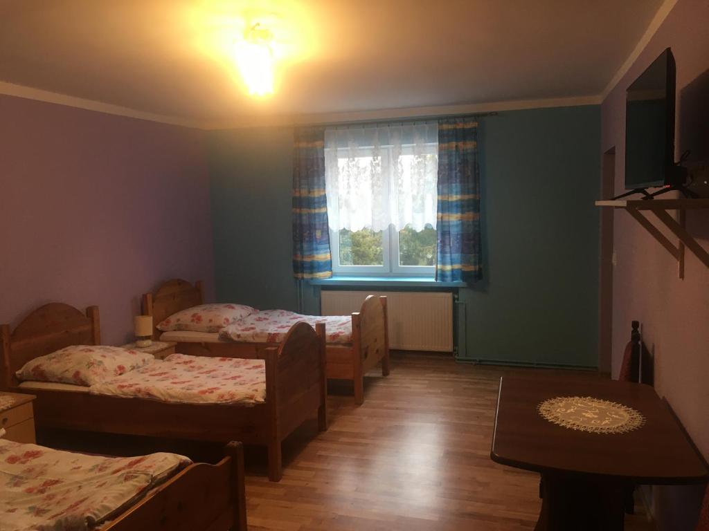 a room with two beds and a window at Agroturystyka pod świerkami in Giebułtów