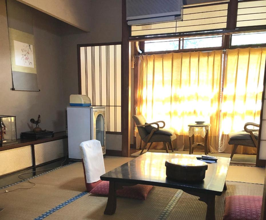 a living room with a table and a large window at Izuya Ryokan - Vacation STAY 22369v in Yugawara