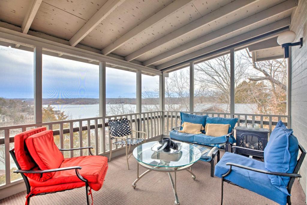 porche acristalado con sillas y mesa de cristal en Resort Home with Hot Tub on Lake of the Ozarks!, en Osage Beach