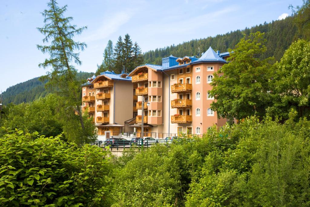 a large apartment building in the middle of a forest at Hotel Chalet Del Brenta in Madonna di Campiglio