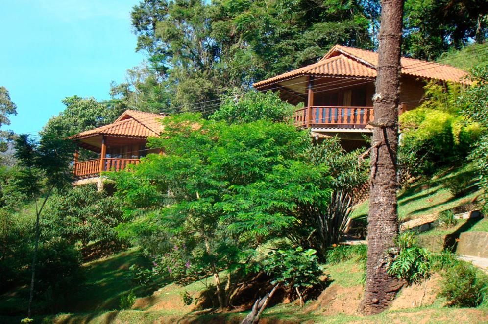una casa in cima a una collina con alberi di Pousada do Mirante a Visconde De Maua